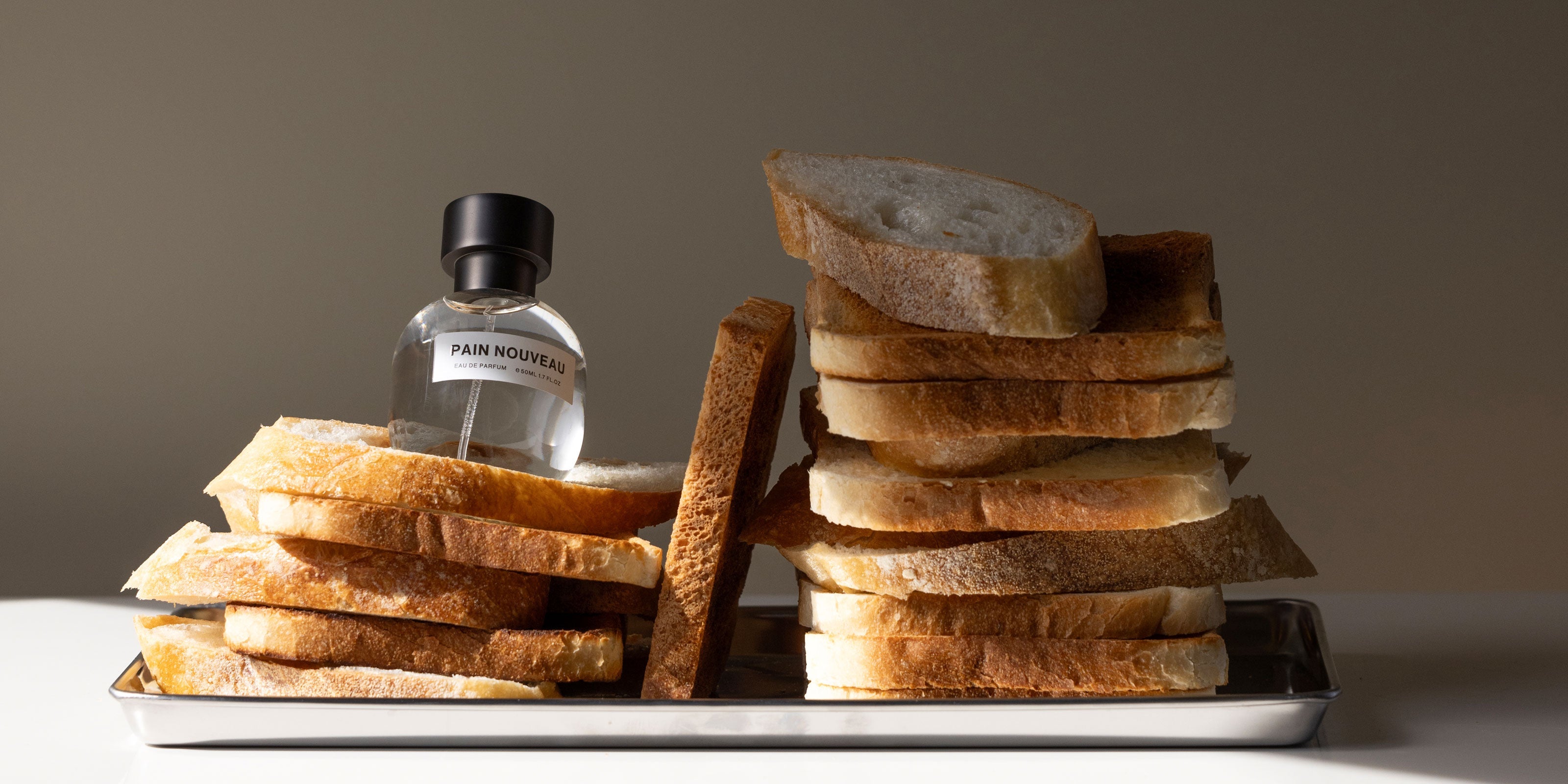 Der Nischenduft Pain Nouveau von Son Venin, der nach Brot riecht, liegt auf Brotscheiben.